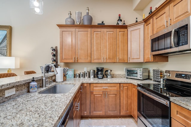 kitchen featuring sink, stainless steel appliances, and light stone counters