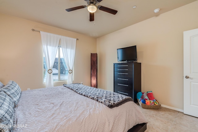 tiled bedroom featuring ceiling fan