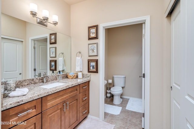 bathroom featuring vanity, tile patterned flooring, and toilet