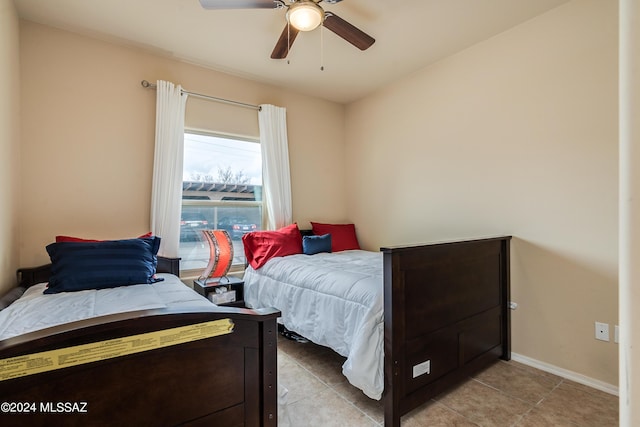 bedroom with light tile patterned flooring, baseboards, and a ceiling fan