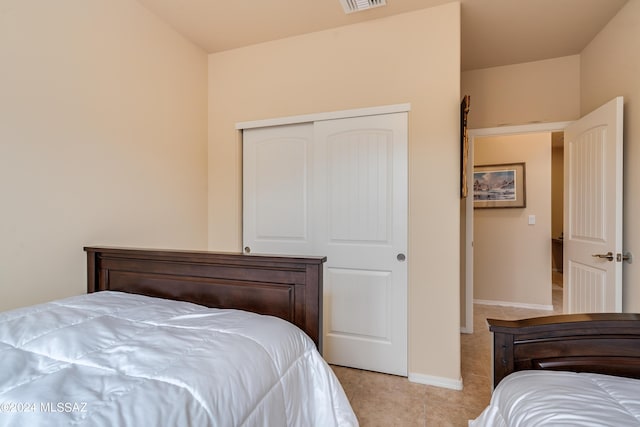 bedroom featuring light tile patterned floors, baseboards, a closet, and visible vents