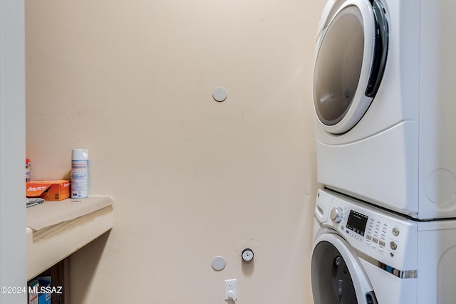washroom featuring stacked washer / drying machine and laundry area