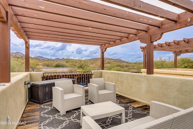 wooden deck with a jacuzzi, outdoor lounge area, a pergola, and a mountain view