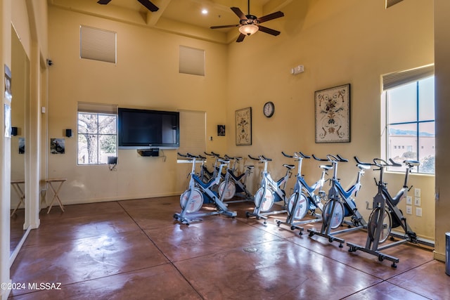 workout area with ceiling fan and a high ceiling