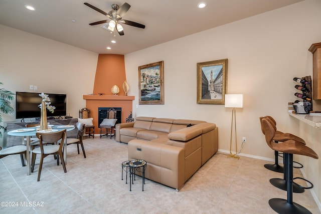 tiled living room featuring a fireplace and ceiling fan