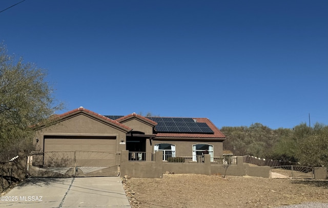 view of front of property featuring a garage and solar panels