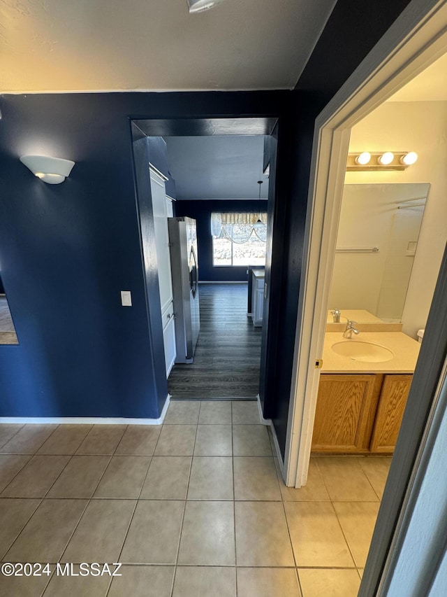 hall featuring light tile patterned floors and sink