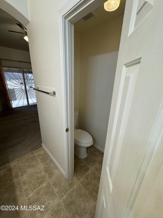 bathroom with toilet, ceiling fan, and tile patterned flooring