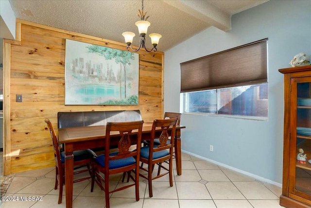 tiled dining room featuring a notable chandelier, wood walls, and a textured ceiling