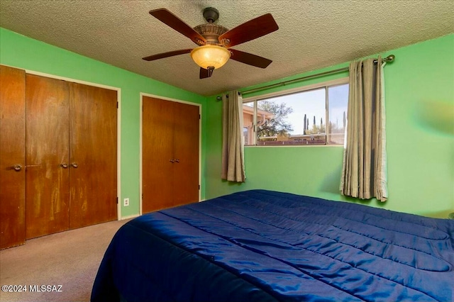 carpeted bedroom featuring a textured ceiling and ceiling fan