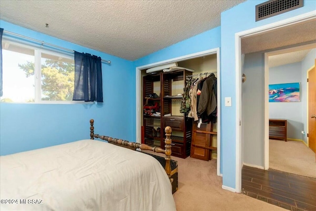 carpeted bedroom featuring vaulted ceiling, a textured ceiling, and a closet