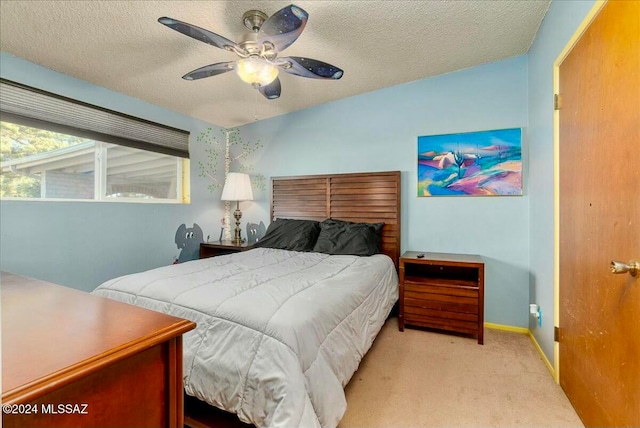 carpeted bedroom featuring a textured ceiling and ceiling fan