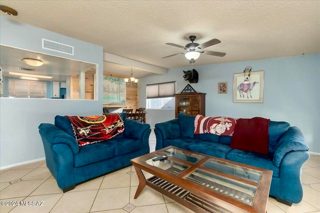 living room featuring ceiling fan with notable chandelier, light tile patterned floors, and a textured ceiling