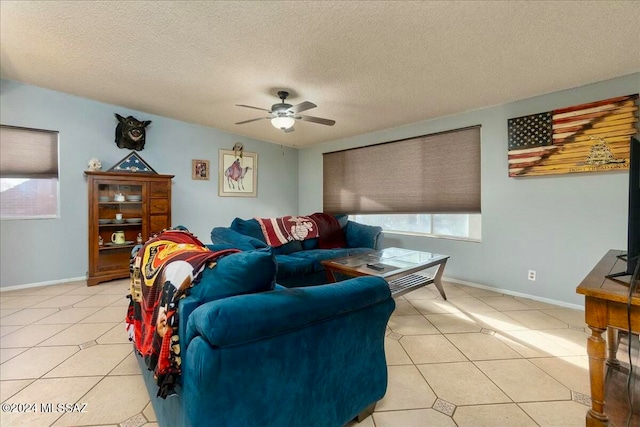 living room with light tile patterned floors, a textured ceiling, and ceiling fan