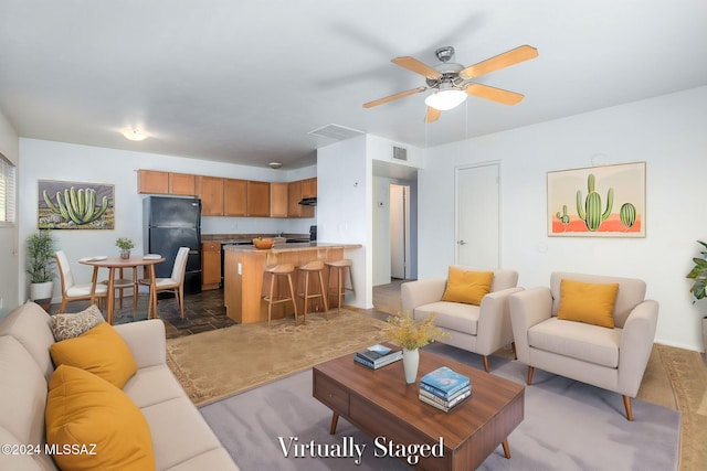 living area with stone finish flooring, visible vents, and a ceiling fan