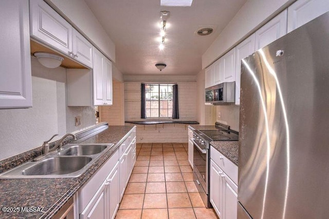 kitchen featuring stainless steel appliances, white cabinetry, and sink