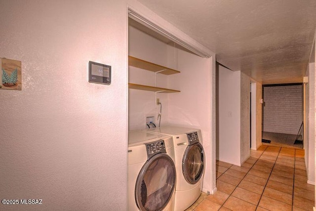 clothes washing area featuring washing machine and clothes dryer and light tile patterned floors