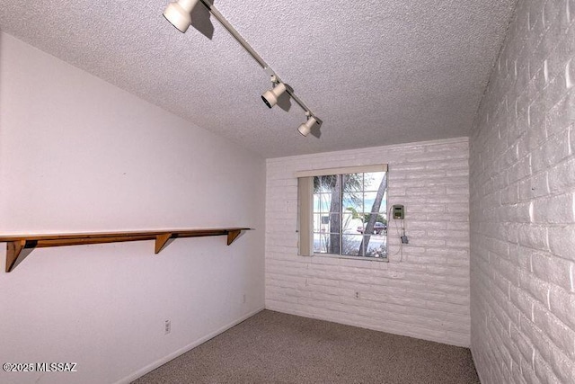 carpeted spare room with track lighting