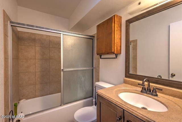 full bathroom featuring vanity, shower / bath combination with glass door, and toilet