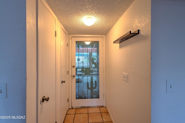 entryway with a textured ceiling and light tile patterned floors