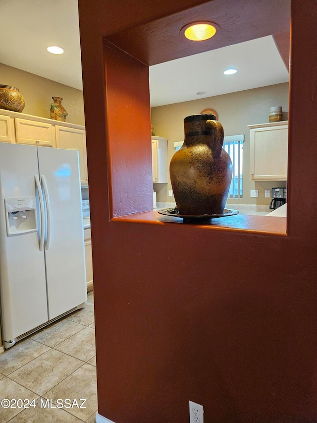 kitchen with white refrigerator with ice dispenser and light tile patterned floors
