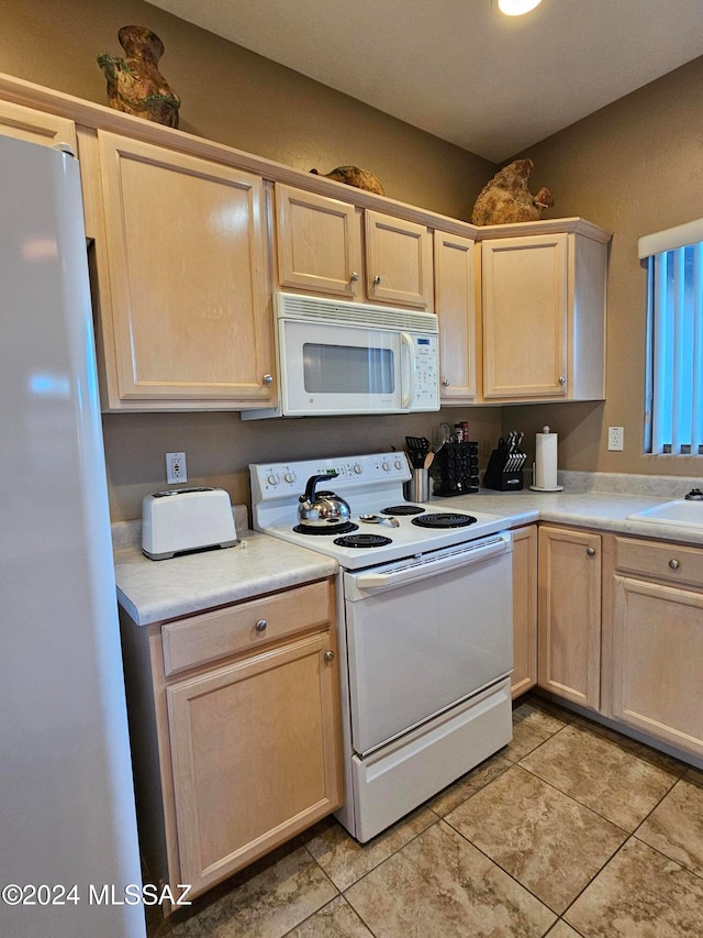 kitchen with light brown cabinets, white appliances, sink, and light tile patterned floors