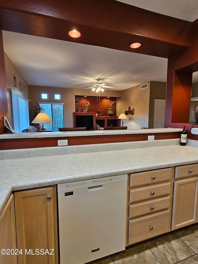 kitchen featuring ceiling fan, light brown cabinets, stainless steel dishwasher, kitchen peninsula, and light tile patterned floors