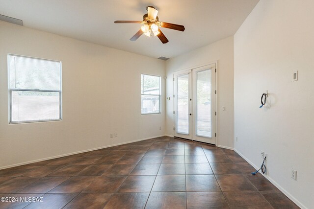 tiled spare room with ceiling fan and french doors