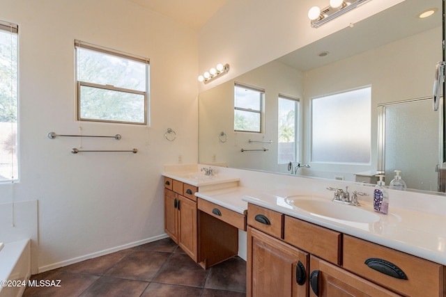 bathroom with tile patterned flooring, shower with separate bathtub, vanity, and a wealth of natural light