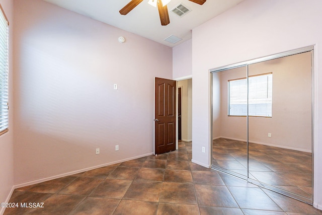 unfurnished bedroom featuring ceiling fan, high vaulted ceiling, and a closet