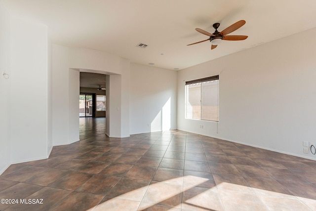 tiled spare room featuring ceiling fan