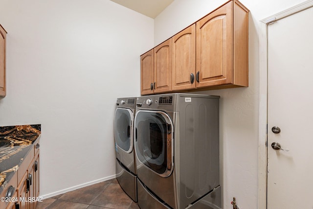 laundry room with washer and clothes dryer, cabinets, and dark tile patterned floors