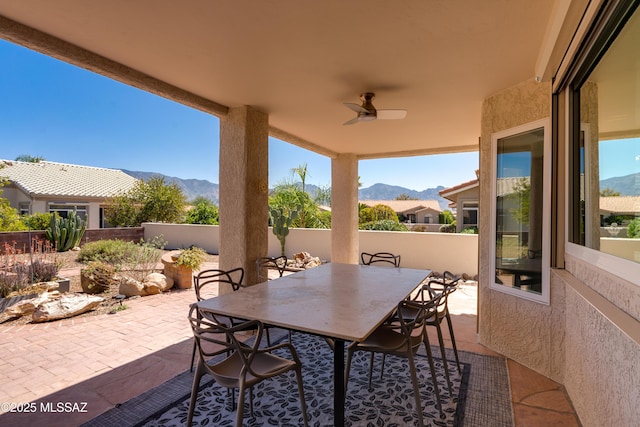 view of patio with a mountain view, outdoor dining area, a ceiling fan, and fence private yard