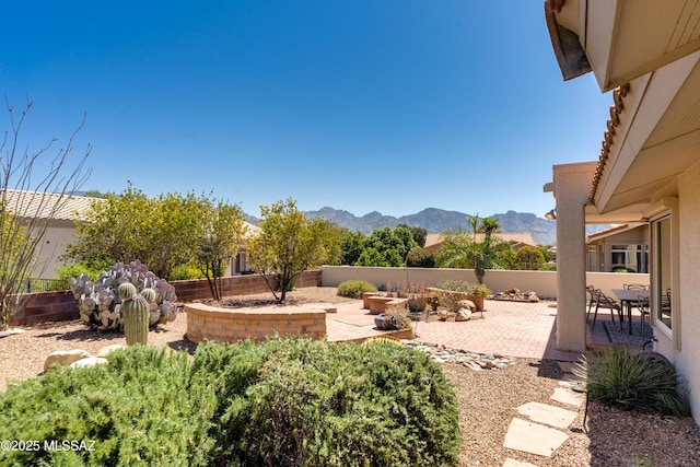 view of yard with fence, a patio area, and a mountain view