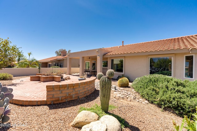 back of property with a patio, fence, a tiled roof, and stucco siding