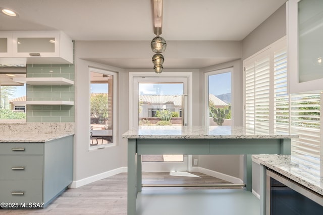 unfurnished dining area featuring baseboards, wine cooler, recessed lighting, and light wood finished floors