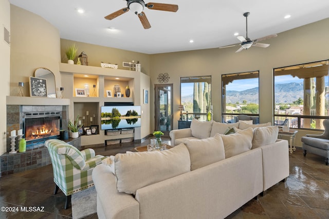 living room with ceiling fan and a fireplace