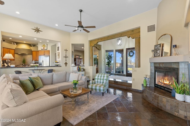 living room featuring a tile fireplace and ceiling fan