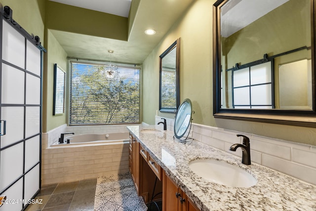 bathroom featuring tile patterned floors, vanity, tiled bath, and a notable chandelier