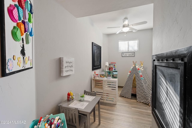 rec room with light hardwood / wood-style floors and ceiling fan