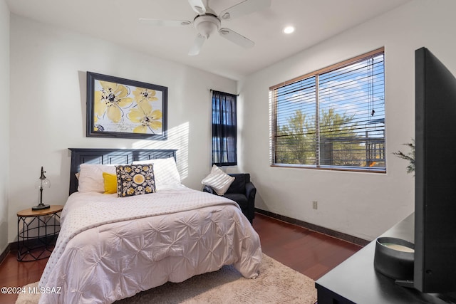 bedroom featuring multiple windows, dark wood-type flooring, and ceiling fan