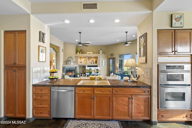 kitchen featuring tasteful backsplash, ceiling fan, sink, and appliances with stainless steel finishes