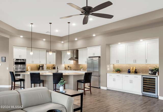 kitchen featuring white cabinetry, wall chimney exhaust hood, stainless steel appliances, wine cooler, and dark hardwood / wood-style floors