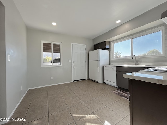 kitchen featuring white appliances, sink, and light tile patterned floors