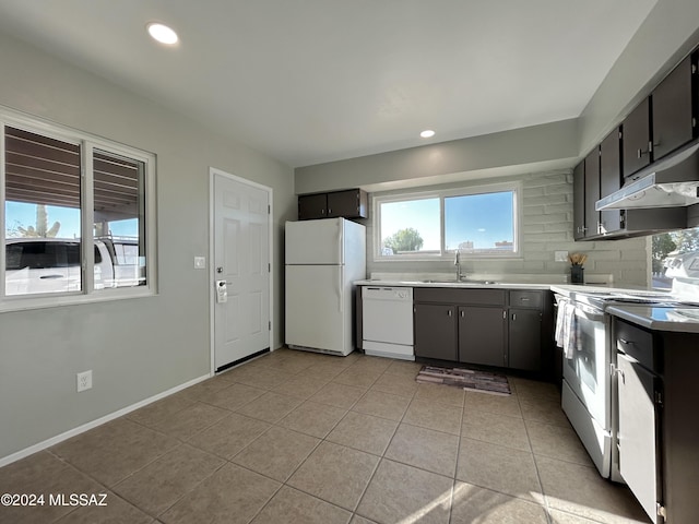 kitchen featuring light tile patterned floors, white appliances, backsplash, and sink