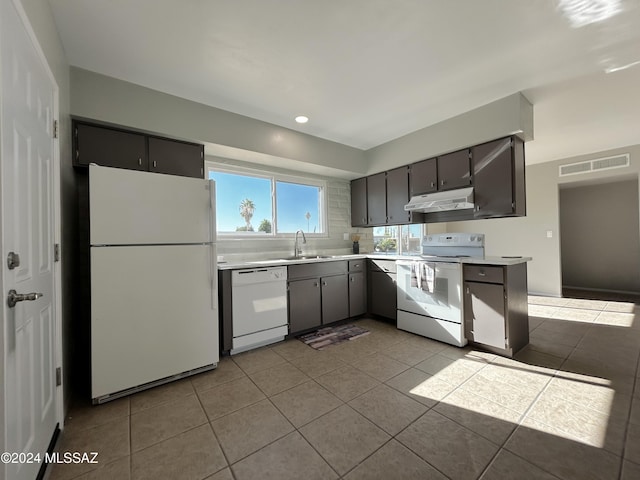 kitchen featuring light tile patterned flooring, white appliances, and sink