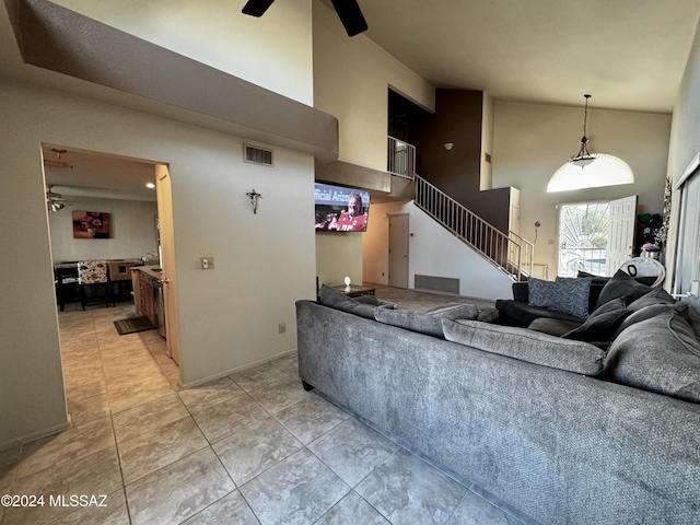 living room with ceiling fan, high vaulted ceiling, and light tile patterned floors