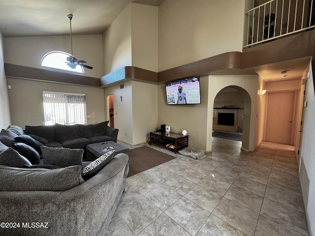 living room with tile patterned flooring, a towering ceiling, and ceiling fan