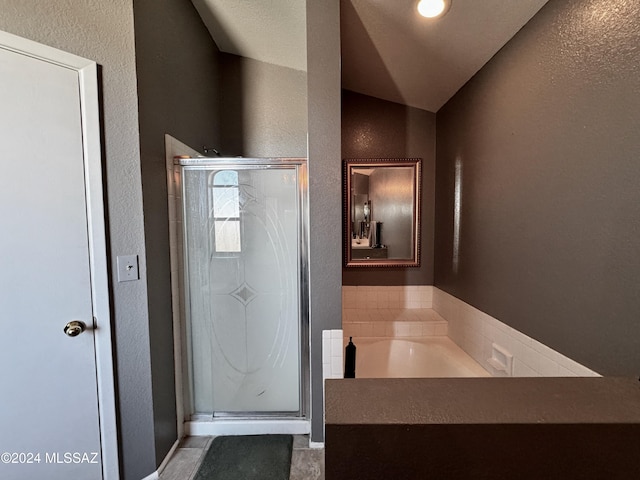 bathroom featuring lofted ceiling and independent shower and bath