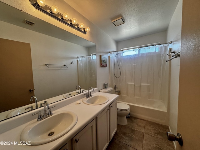 full bathroom featuring shower / tub combo with curtain, vanity, toilet, tile patterned floors, and a textured ceiling